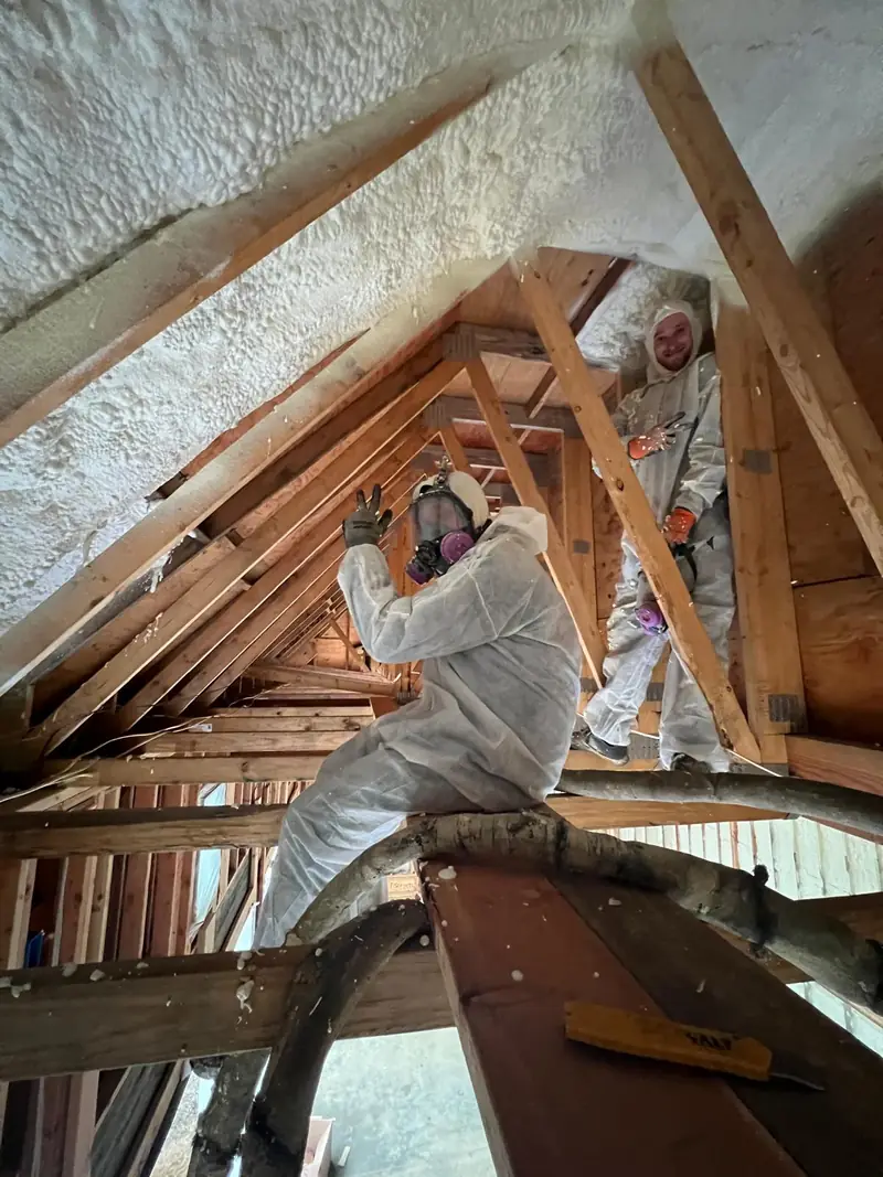 Residential attic spray foam crew wearing protective equipment