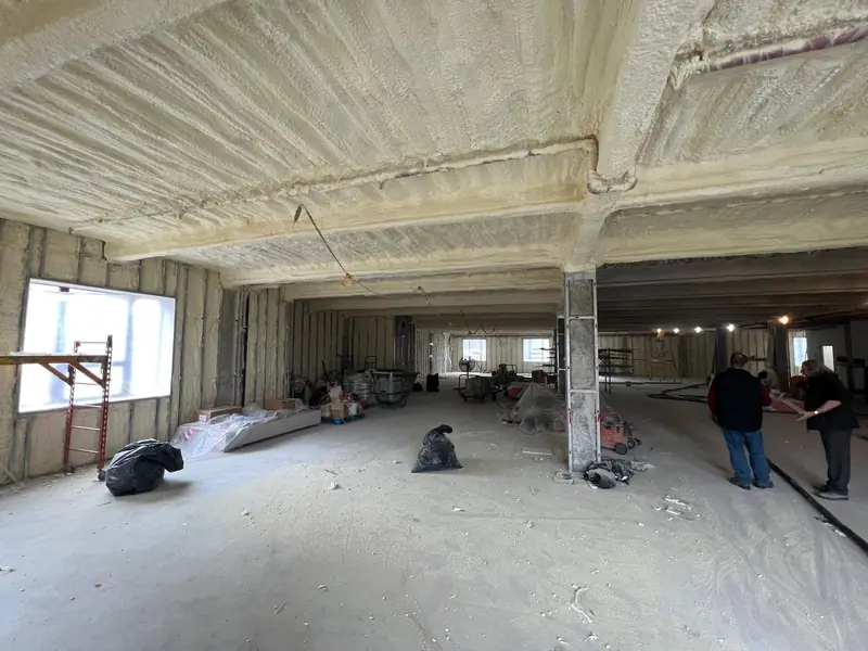 Spray foam insulation installed beneath a corrugated commercial roof deck