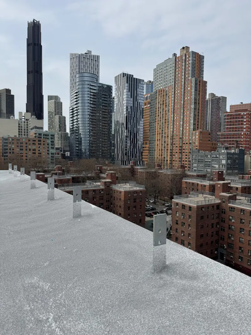 Completed coated SPF flat roof surrounded by urban buildings
