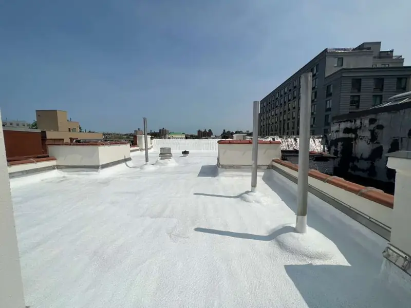 White-coated SPF flat roof with roof penetrations and perimeter details