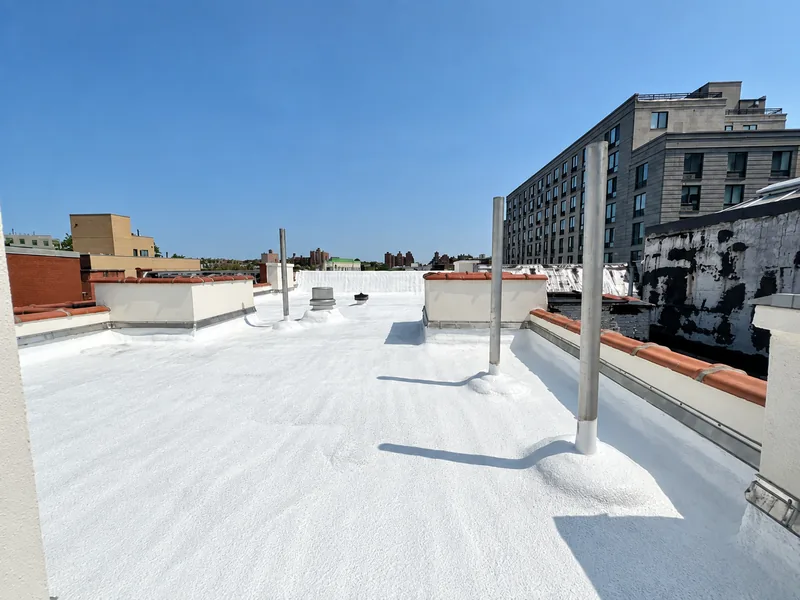 Finished white-coated SPF commercial flat roof with penetrations and edge details
