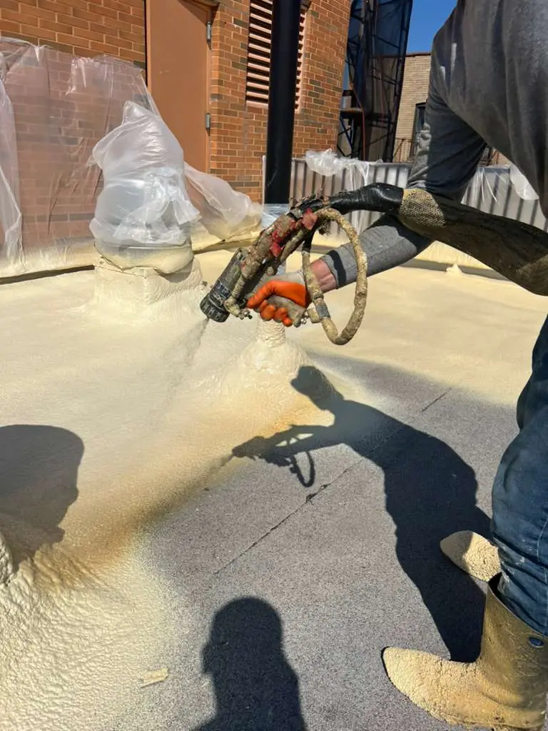 Close view of spray polyurethane foam being applied at a roof detail